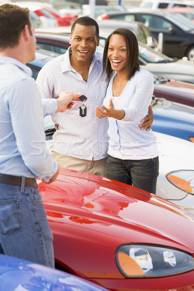 82796 stock photo couple picking up new car from salesman