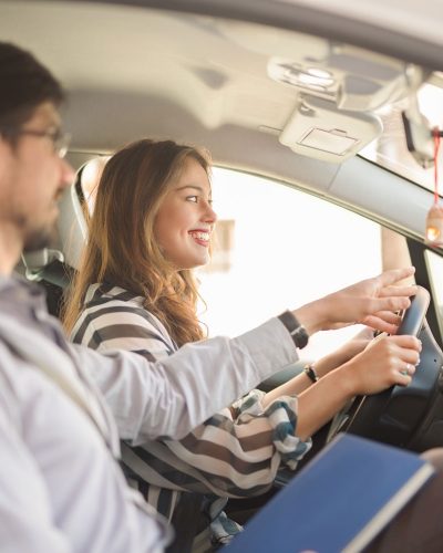 young driver learning how to drive with a driving insrtuctor 400x500 1